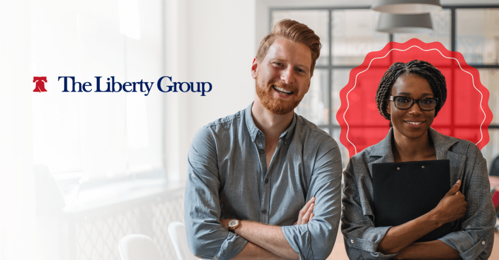 Two professionals smiling, one holding a clipboard, with The Liberty Group logo on the side.