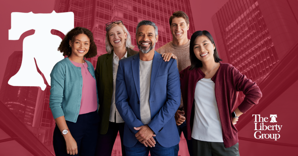 Five employees stand and smile at the camera; The Liberty Group logo is in the bottom right corner.