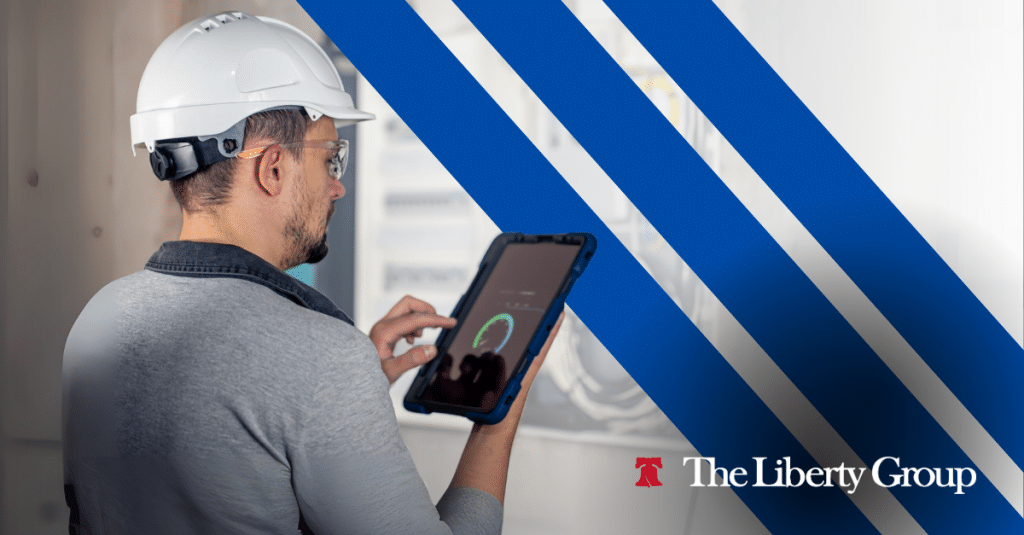 Maintenance worker wearing hard hat and using tablet onsite.