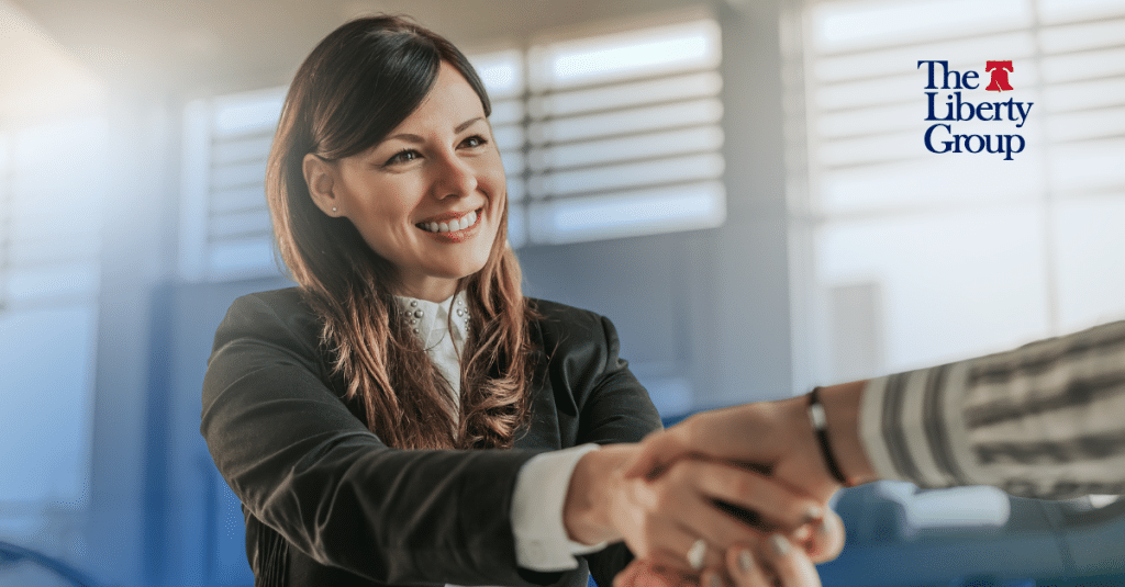 Smiling property manager shaking hands, representing employee loyalty in property management teams.