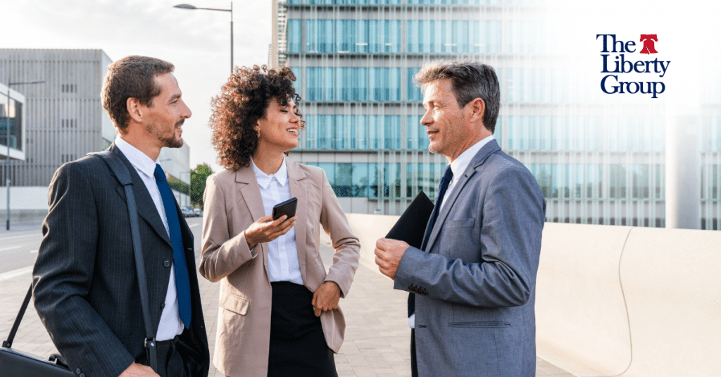 Business professionals having a discussion outdoors in front of a modern office building.